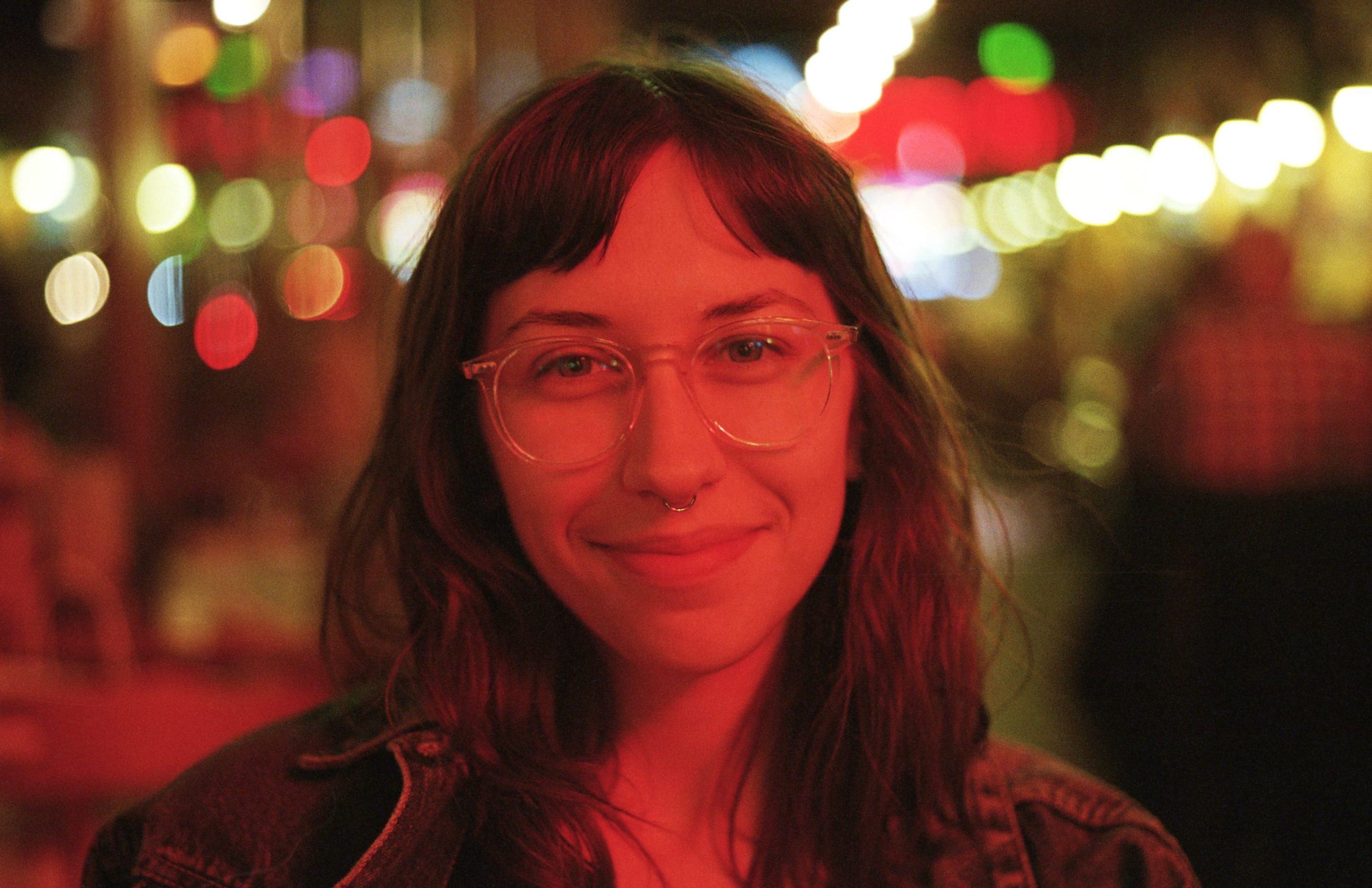 Portrait of Natalie Kilimnik outdoors at night under the glow of a red light.